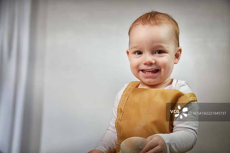 一个小男孩在创意烹饪主题活动中快乐地玩面粉图片素材