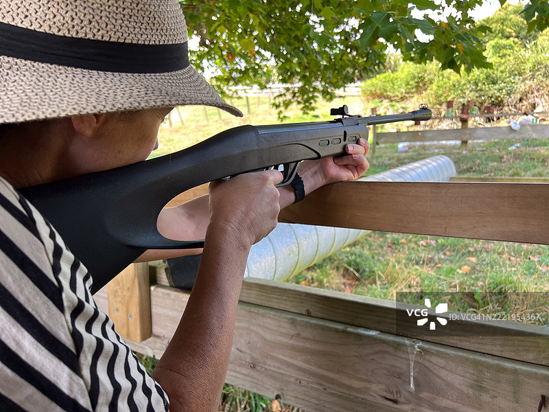 中年女性使用气枪射击靶子图片素材