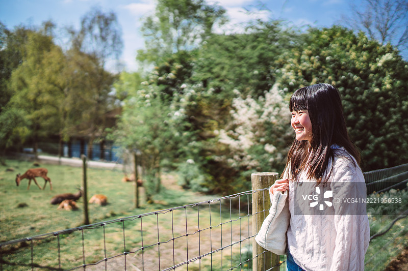 微笑的少女在野生动物园享受一天的乐趣图片素材