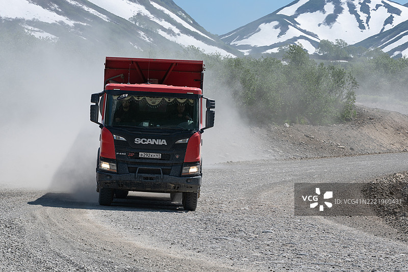 斯堪尼亚P440 12轮自卸卡车正在山区的碎石乡村道路上行驶图片素材