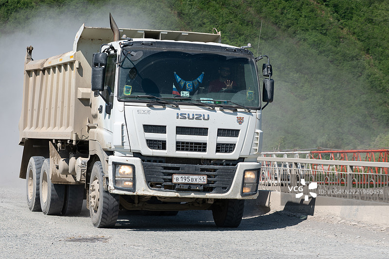五十铃CYZ自卸车在乡村的碎石路上行驶。图片素材