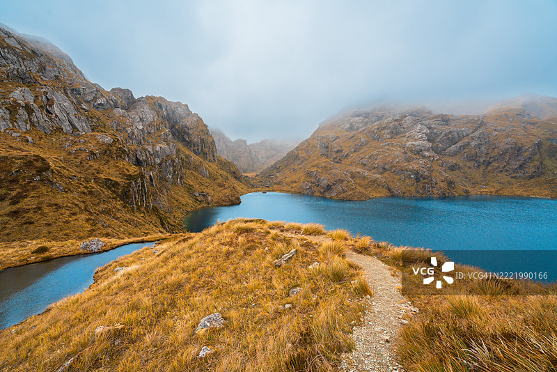 宁静的湖泊坐落在起伏的山丘之间。图片素材