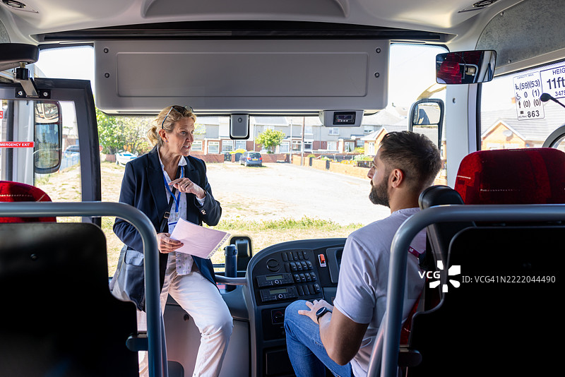旅行社代理人与巴士司机交谈图片素材