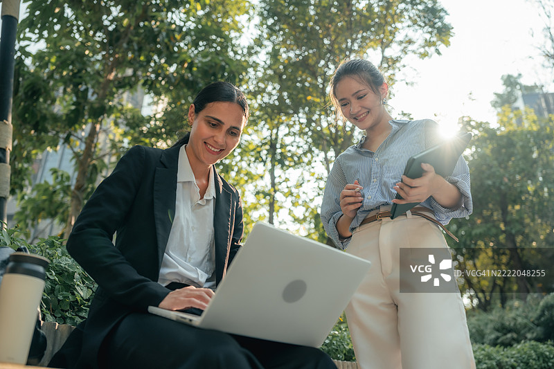 快乐的女性员工在导师的指导下，热切地学习并进行她的第一个项目。图片素材