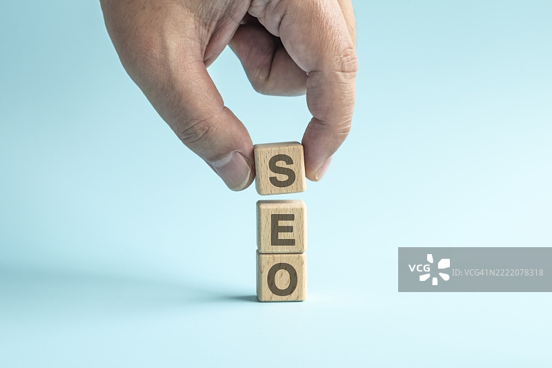 成人手叠放木制积木块与SEO文本图片素材