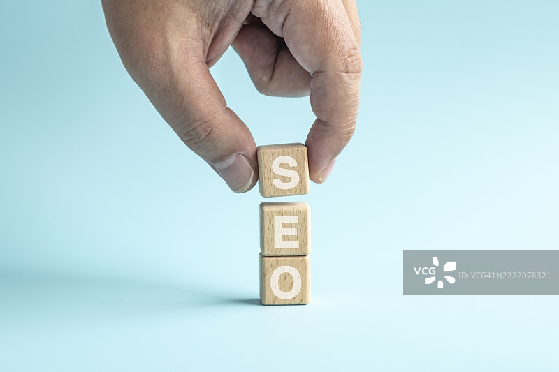 成人手叠放木制积木块与SEO文本图片素材