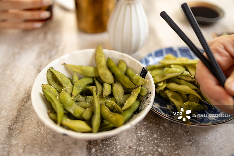 完美准备的毛豆，撒上盐，盛在乡村风格的时尚碗中。图片素材