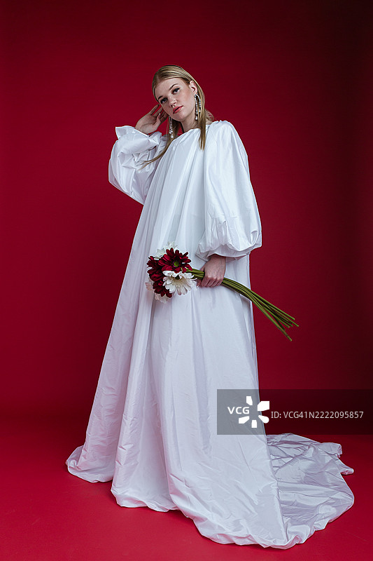 时尚女性自信地摆姿势，穿着白色服装图片素材