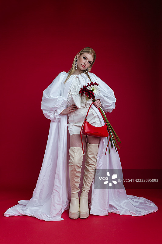 时尚女性自信地摆姿势，穿着白色服装图片素材