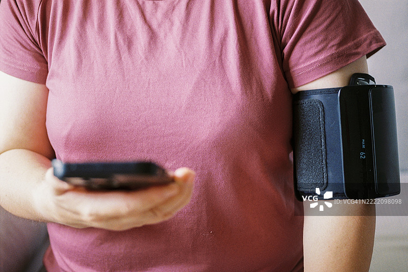 成熟的亚洲女性使用数字血压监测仪检查健康数据图片素材