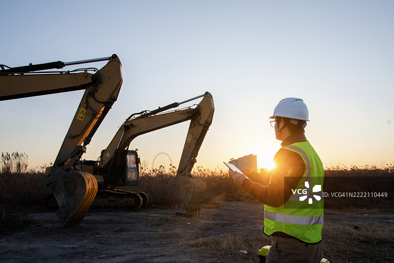 亚洲工程师在建筑工地上使用数字平板电脑图片素材