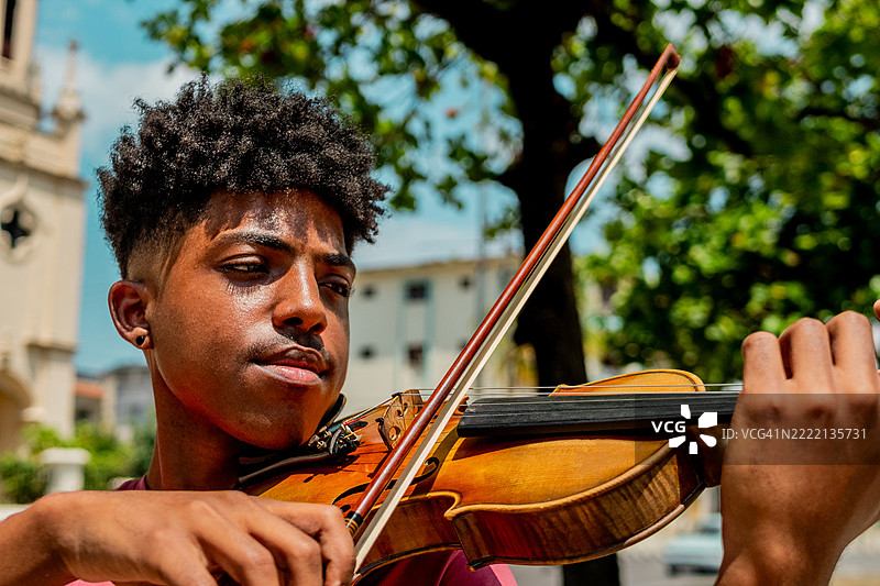 年轻男子在户外拉小提琴图片素材