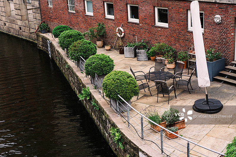 河边露台，配有座椅、植物和红砖墙概览图片素材