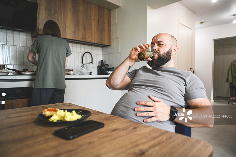 男人喜欢吃东西，因暴饮暴食而腹痛图片素材