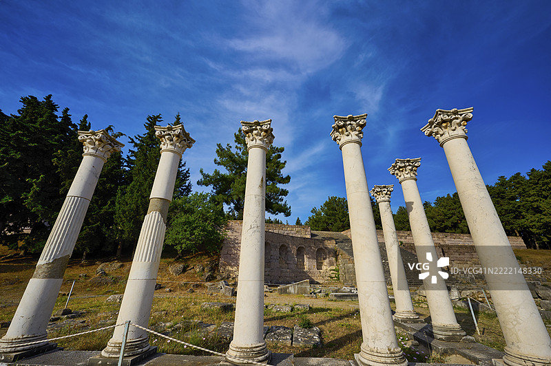 古希腊阿波罗神庙前,成排的科林斯柱式建筑,蓝天与饱满的树木映衬,这里曾是希波克拉底时期著名的阿斯克勒庇俄斯(希腊语:Ασκληπιείο,意为治愈神庙)所在地,位于希腊科斯岛(Kos)的多德卡尼斯群岛(Dodecanese)上,属于欧洲。图片素材
