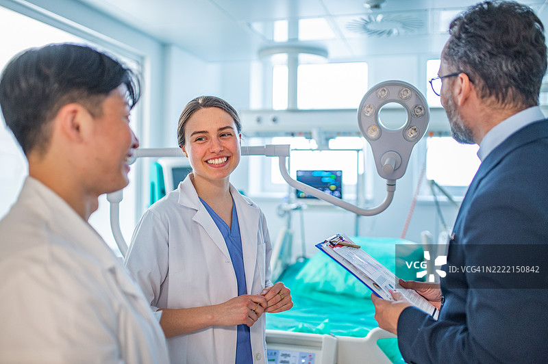 制药公司销售员与医生交谈，展示新医疗技术。图片素材