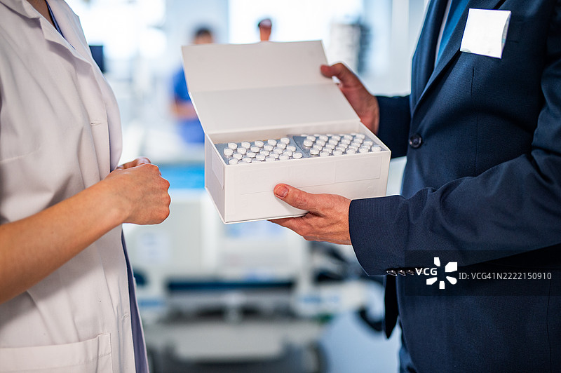 制药销售代表与年轻医生握手，介绍新药物。图片素材