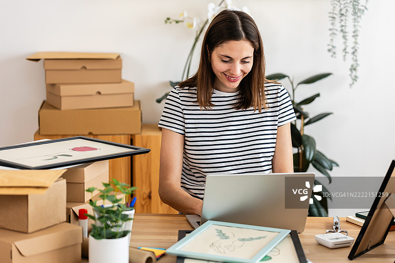 年轻女性艺术家在艺术工作室管理在线订单图片素材