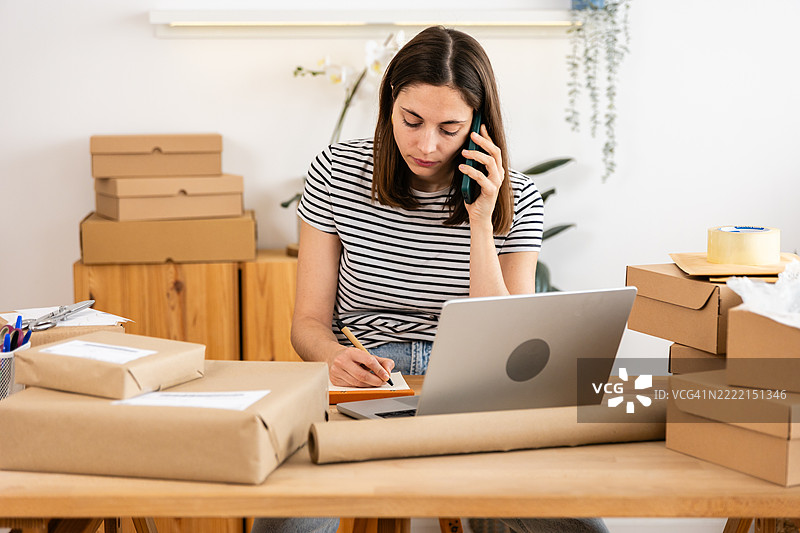 小企业主在家庭办公室管理订单和发货图片素材