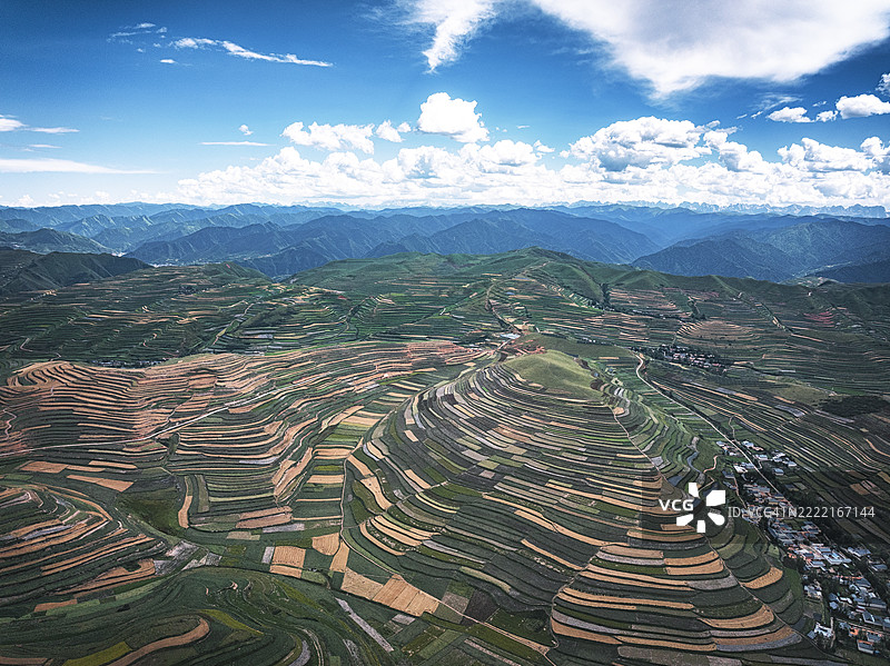 甘肃省甘南藏族自治州临潭县的山脉、梯田和特色小镇的无人机照片图片素材