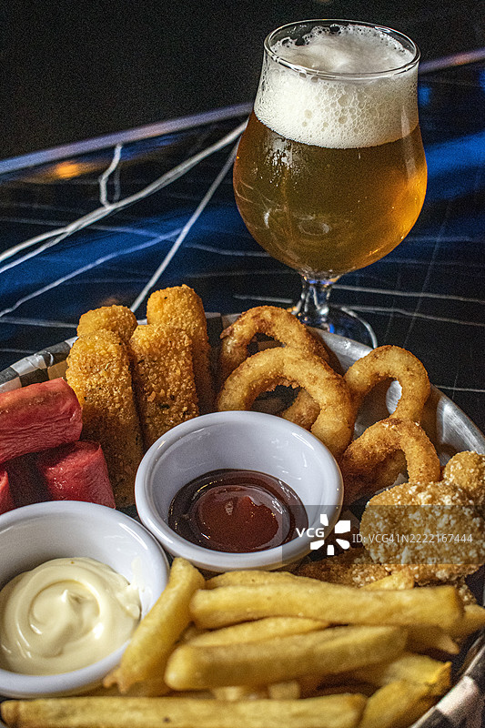 薯条、香肠、马苏里拉奶酪条、面包圈洋葱圈和一杯手工啤酒 - 美食图片素材