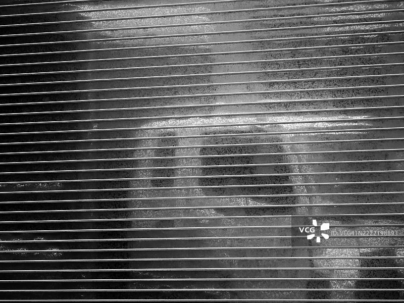 金属车库门的特写，上面反射着一辆卡车。美国纽约州曼哈顿。阳光。黑白。图片素材