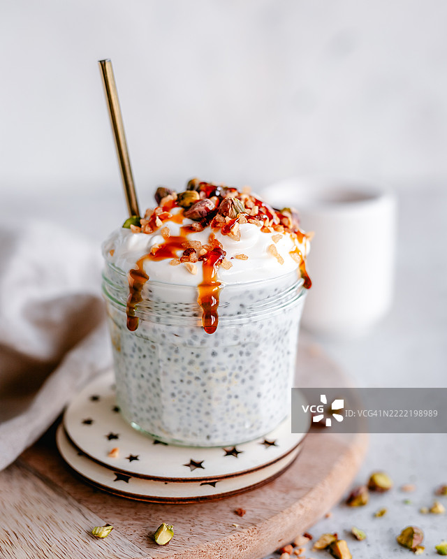 装有酸奶、坚果和糖浆的奇亚籽布丁罐子图片素材