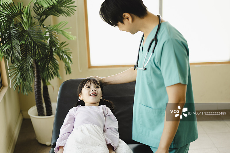 微笑的孩子与关心的医疗专业人士互动图片素材