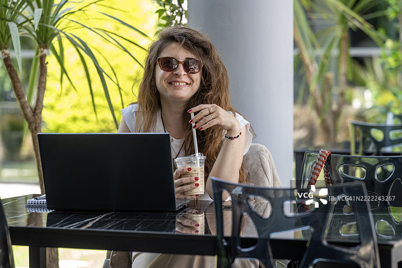 微笑的女性在笔记本电脑上打字的特写镜头图片素材