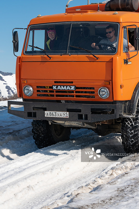 一辆俄罗斯越野客运探险卡车（卡玛斯）在雪山公路上行驶的驾驶舱特写视图图片素材
