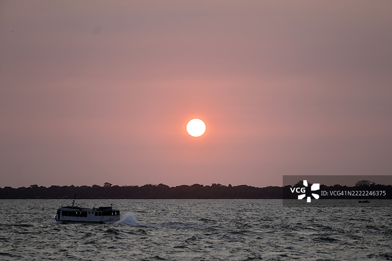 巴西瓜亚拉湾的日落与航行中的船只图片素材