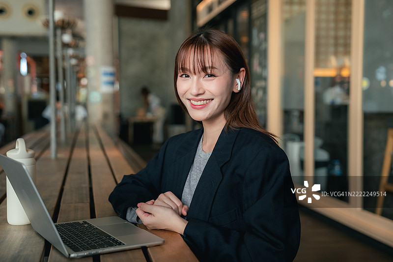 创业女商人正在充满活力的共享办公咖啡馆里，通过笔记本电脑与商业伙伴进行虚拟会议。图片素材