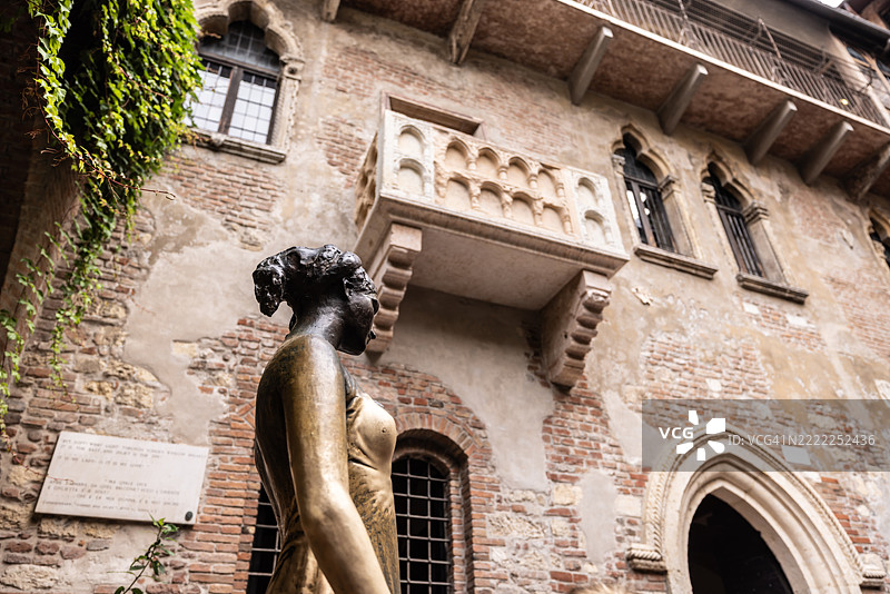 从下方俯瞰意大利维罗纳的朱莉亚·卡布莱特的青铜雕像及其阳台。图片素材