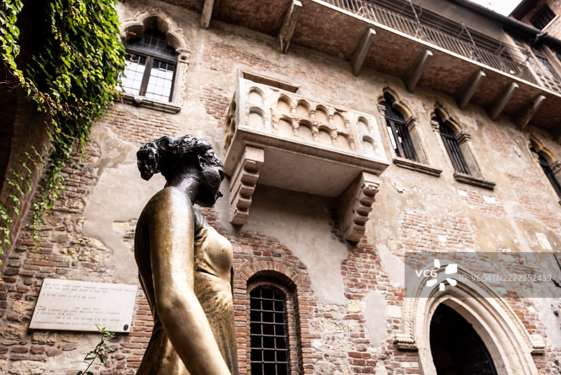 从下方俯瞰意大利维罗纳的朱莉娅·卡布莱特青铜雕像及其阳台。图片素材