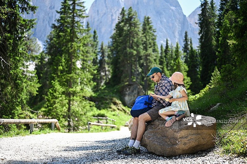 父亲和女儿在多洛米蒂山脉徒步旅行时享受小吃图片素材