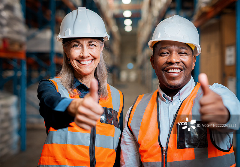 穿着安全装备的多元化物流团队在仓库中竖起大拇指图片素材