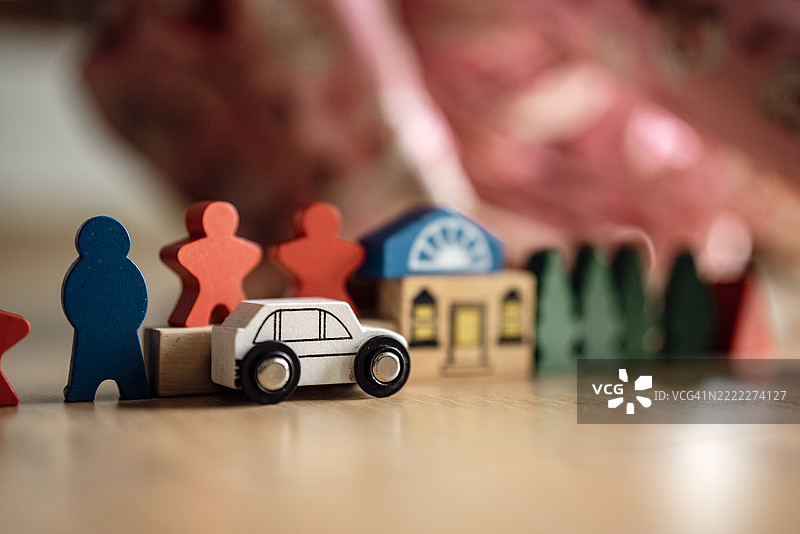 小女孩在地板上玩五彩斑斓的木制教育玩具，通过富有想象力的游戏发展技能和创造力。图片素材