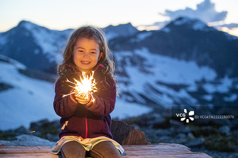 年轻女孩在山顶上手持烟花棒图片素材