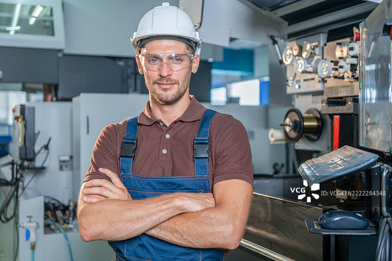 工厂工人在用平板电脑编程数控铣床。图片素材