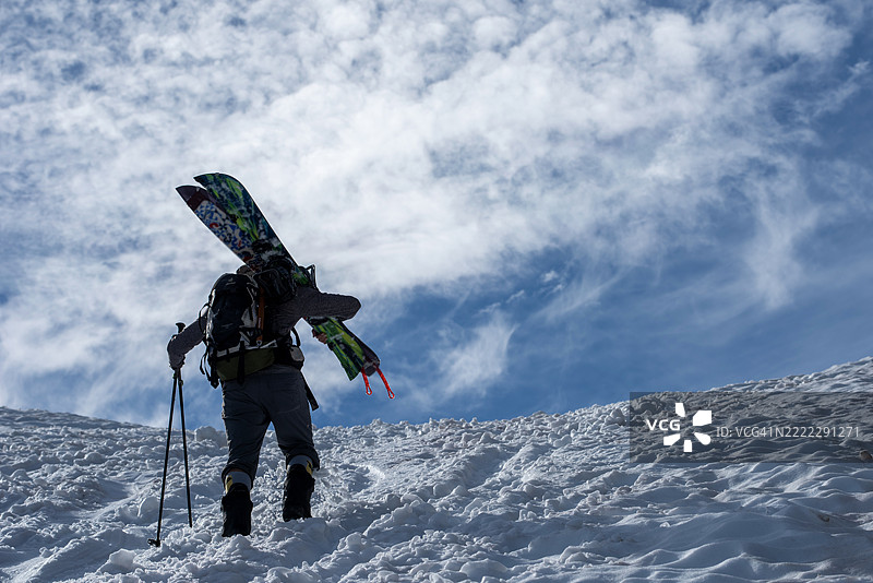 越野滑雪板爱好者攀登山脊图片素材