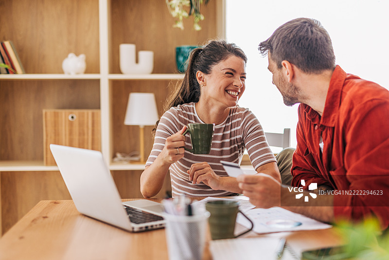 一对情侣在家中愉快地进行网上购物图片素材