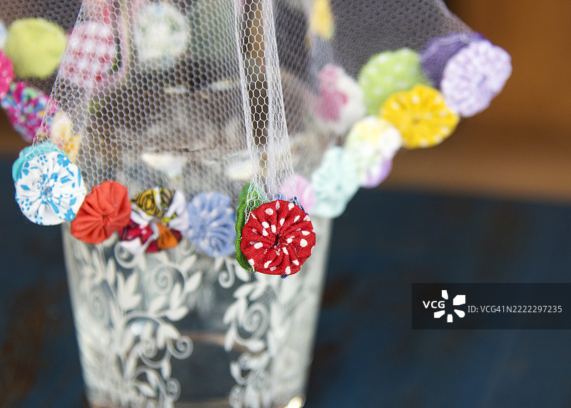 用手工花边装饰的薄纱，用于夜间保护水杯。图片素材