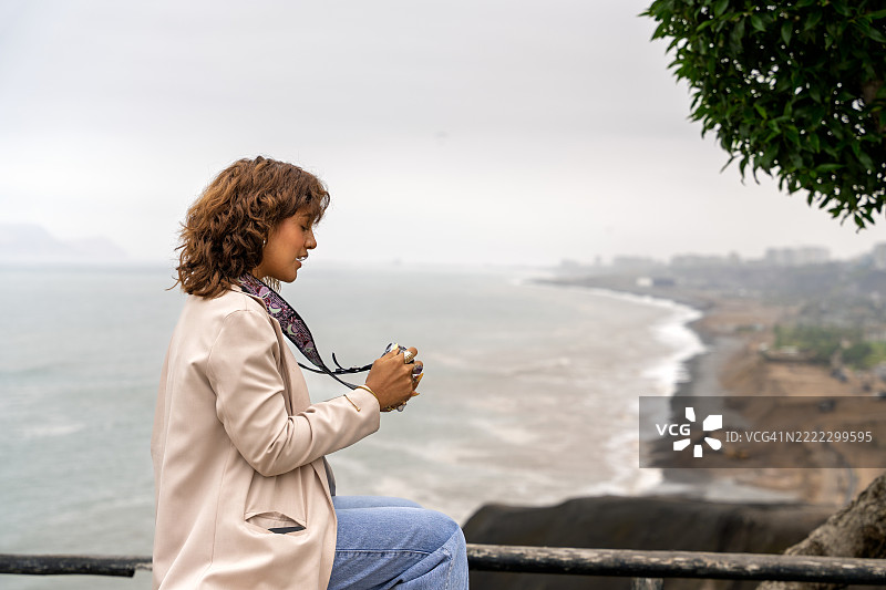 网红在海滨长廊上创作内容，俯瞰大海图片素材