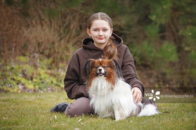 坐在草地上的女孩和狗图片素材