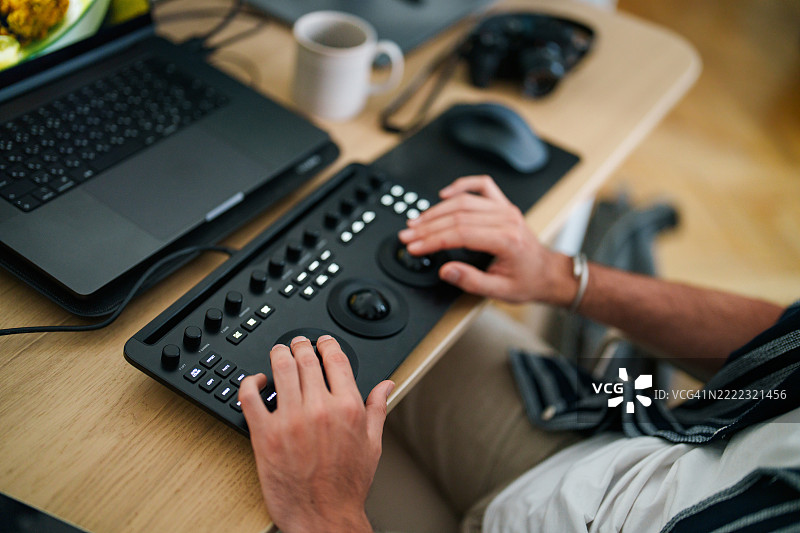 特写：电影编辑在工作桌上使用色彩编辑板的手图片素材