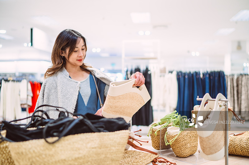 女性在零售店购物，寻找环保时尚配饰图片素材