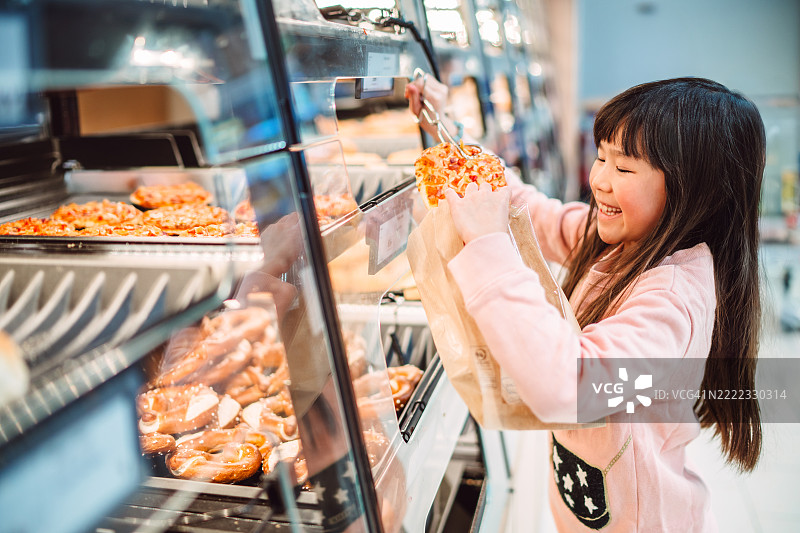 快乐的孩子在超市面包店挑选新鲜出炉的烘焙食品图片素材