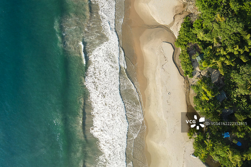 空中俯瞰一个天堂般的荒无人烟的海滩，周围环绕着热带森林，巴西，里约热内卢图片素材