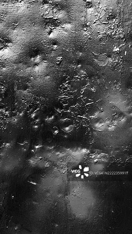 凹陷的金属板特写,涂成黑色并有锈蚀痕迹。粗糙的纹理。美国纽约州曼哈顿。阳光。黑白色调。全画幅16x9。图片素材