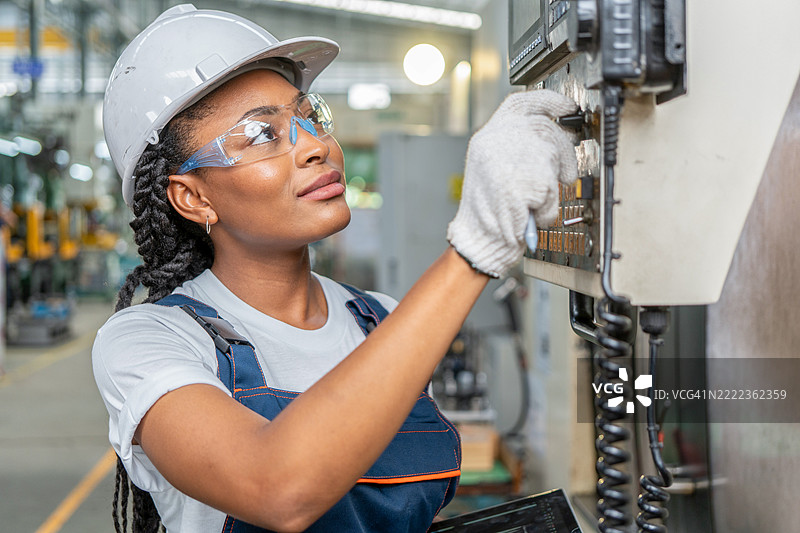 女性工程师在工业厂房内工作，身处金属工厂，属于重工业领域。图片素材